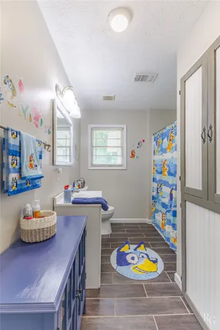This bright bathroom features durable tile flooring, providing a clean and inviting space.