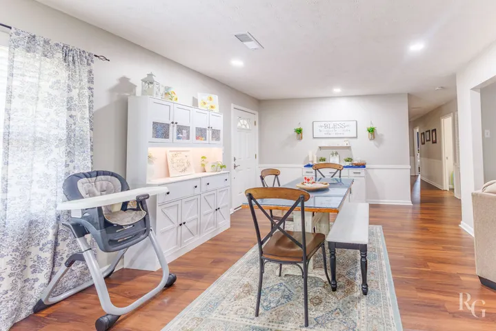 This inviting dining area features warm wood flooring, offering a comfortable and functional space.