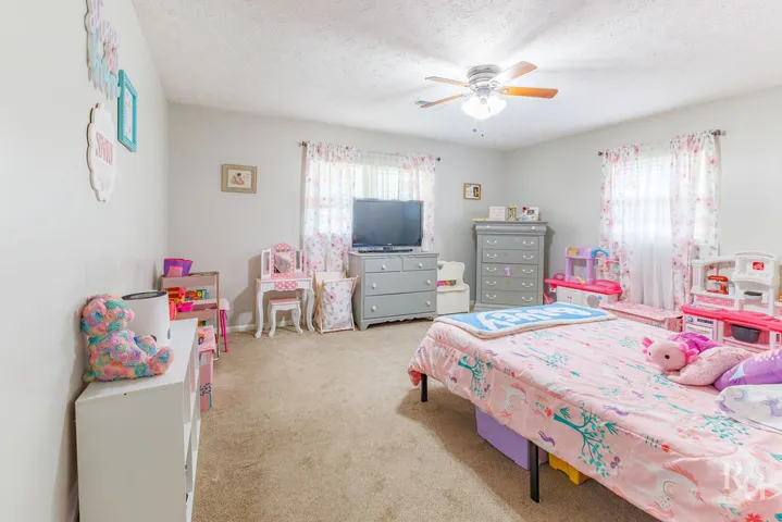 This cozy bedroom offers ample space and a comfortable atmosphere for relaxation.