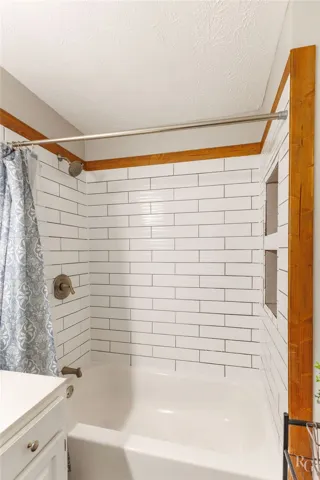 This bathroom features crisp tile work and a convenient tub and shower combination.