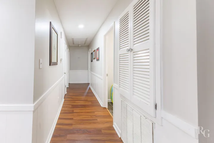 This spacious hallway features attractive flooring and classic wainscoting.