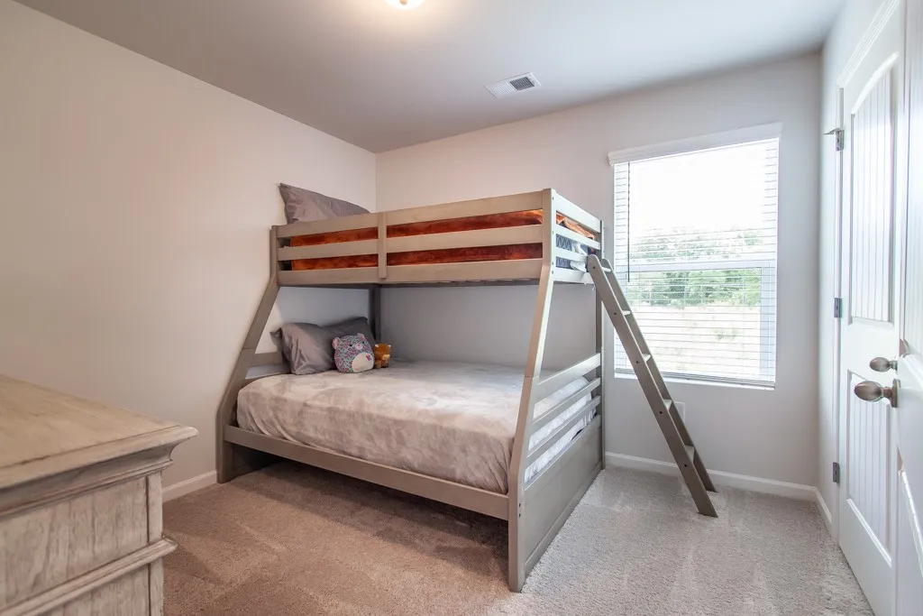 This cozy bedroom features comfortable bunk beds, ideal for maximizing space and creating a playful atmosphere.