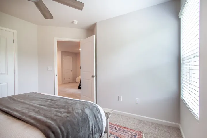 This spacious bedroom offers comfortable living with soft carpeting and natural light.