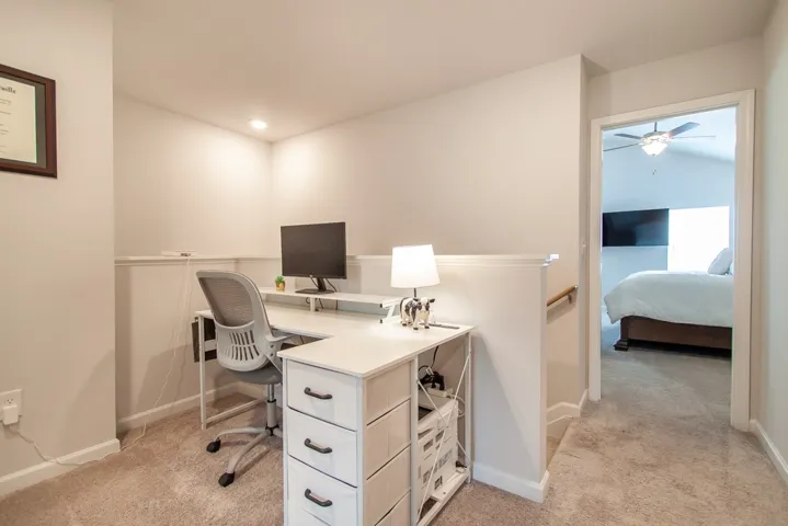 This versatile loft area provides a functional workspace and seamlessly connects to an adjacent bedroom.