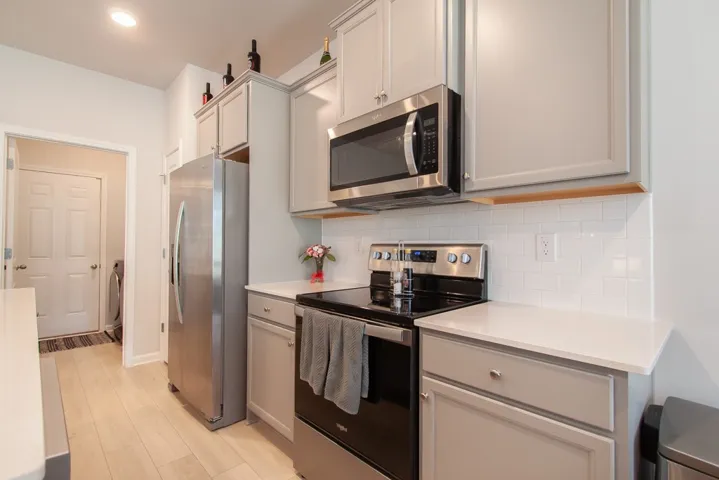 This modern kitchen features light cabinetry and stainless steel appliances.