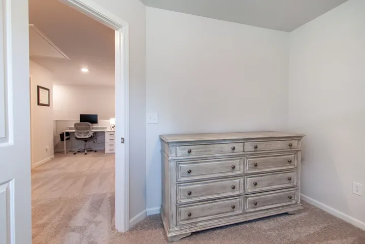 This versatile room offers plush carpeting, leading to an adjoining space perfect for work or relaxation.