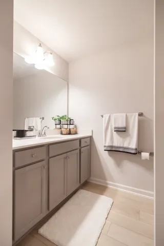 This clean and inviting bathroom features a spacious vanity and light-toned flooring.