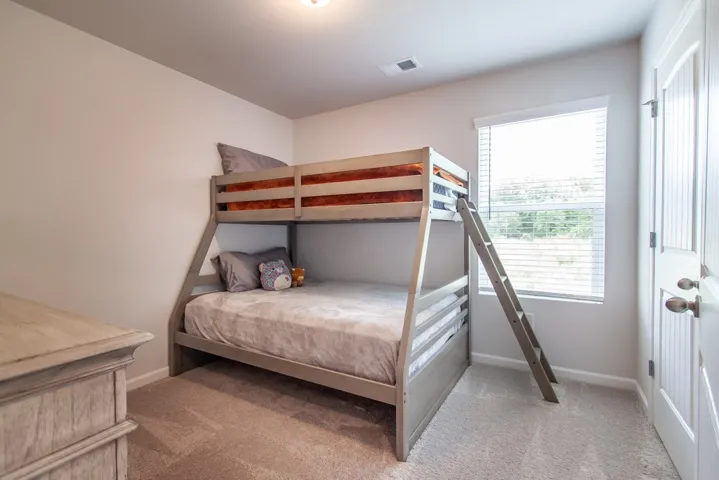 This cozy bedroom features comfortable bunk beds, ideal for maximizing space and creating a playful atmosphere.