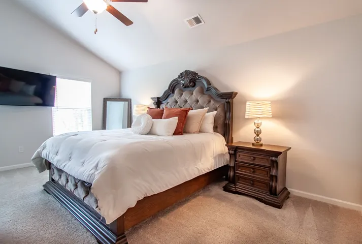 This spacious bedroom offers a tranquil retreat with plush carpeting and vaulted ceilings.