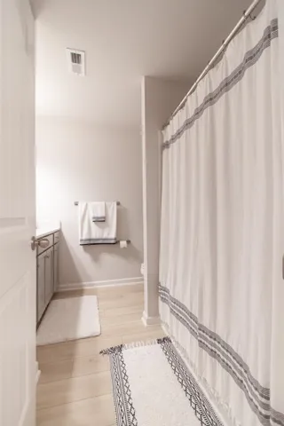 This bright bathroom features light flooring and a convenient shower area.
