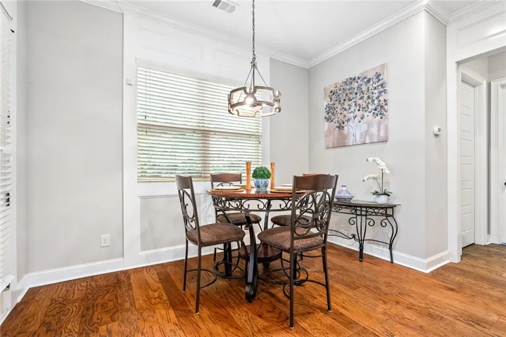 This inviting dining area features elegant hardwood flooring and ample natural light.