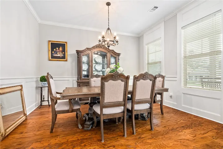 This elegant dining room features rich wood flooring and classic architectural details, creating a refined atmosphere.