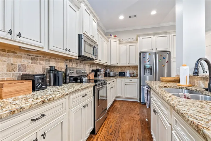 This bright kitchen features ample cabinetry, durable countertops, and sleek stainless steel appliances.
