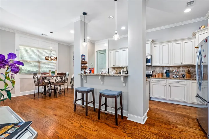 This inviting space features an open-concept kitchen and dining area with warm hardwood flooring.