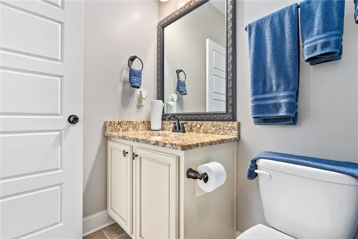 This bathroom features a sleek vanity with granite counters and a clean design.