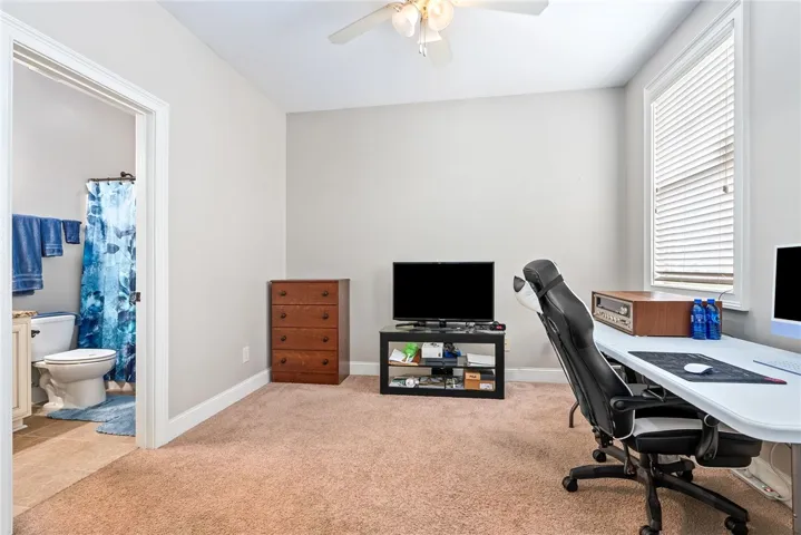 This cozy space features a dedicated work area and convenient access to a private bathroom.