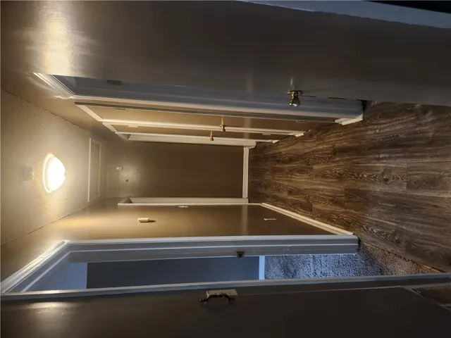 This hallway features a harmonious blend of wood and carpeted flooring, complemented by recessed lighting.