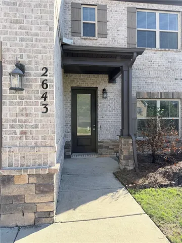 This inviting home features a covered entryway with a beautiful blend of brick and stone.
