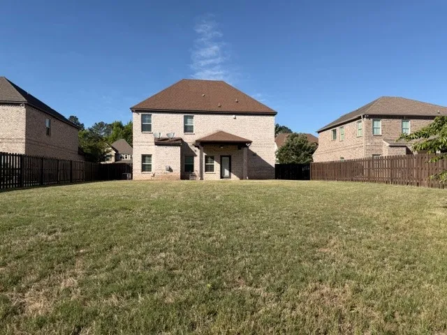 A spacious backyard with mature landscaping and a well-maintained lawn.
