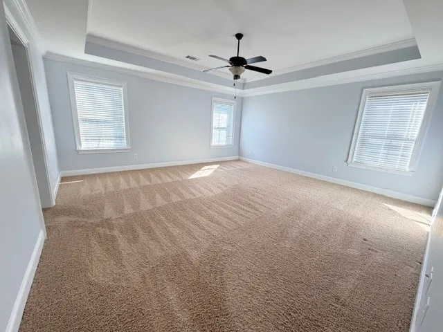 This spacious bedroom offers ample natural light and a comfortable atmosphere for rest and relaxation.