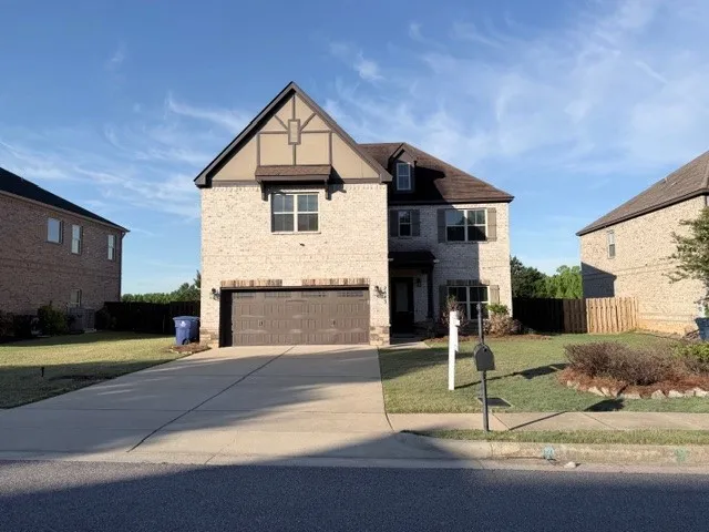 This charming home showcases a classic brick exterior, inviting landscaping, and a convenient attached garage.