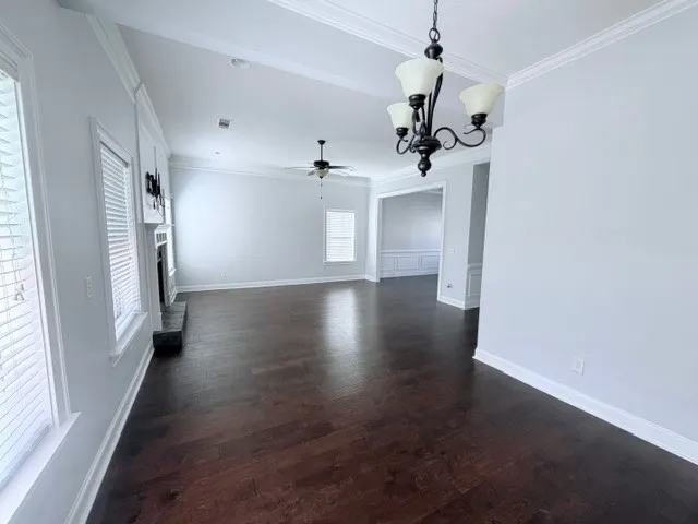 This expansive living space features rich hardwood floors and elegant crown molding throughout.