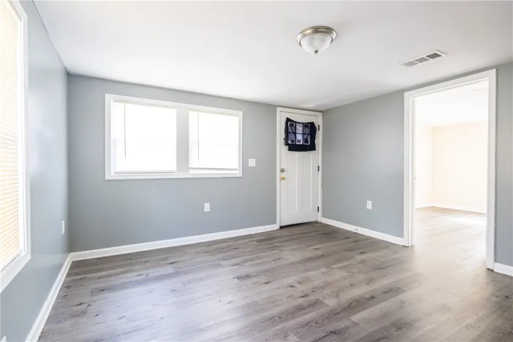 This living room features modern flooring and ample natural light, creating an inviting atmosphere.