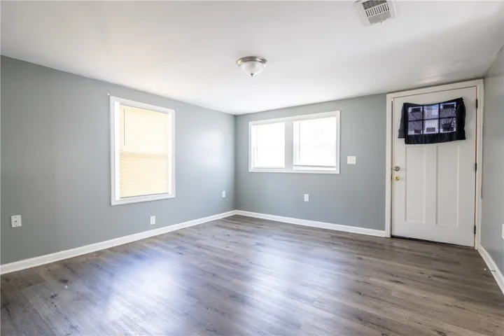 Bright and open room features durable flooring and ample natural light, ideal for various living arrangements.