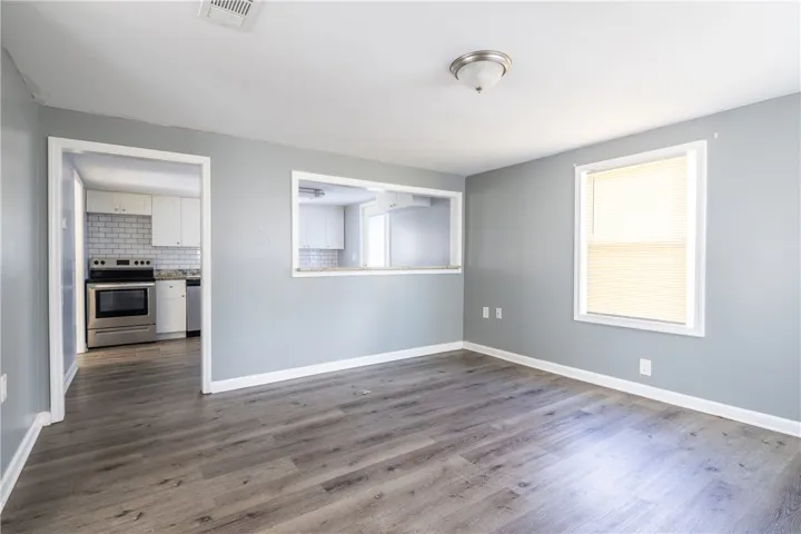 This bright living space features durable flooring and a convenient pass-through window to the kitchen.