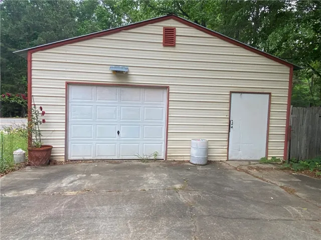 This functional garage offers practical storage and convenient access with an attached shed for versatile use.