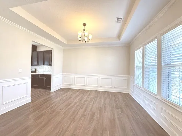 This versatile space features a tray ceiling and durable hardwood flooring, perfect for various activities.
