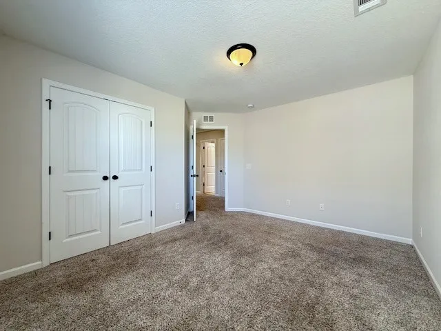 This spacious bedroom offers ample space and comfortable carpeting.