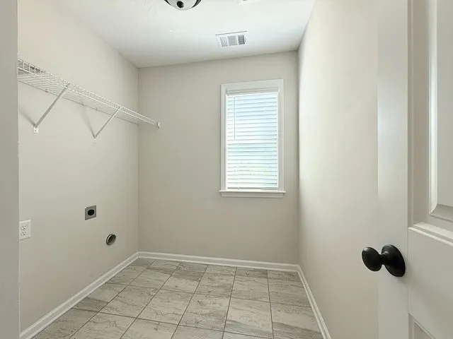 This dedicated laundry room provides convenience and a bright atmosphere for daily chores.