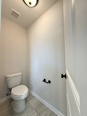 Functional half bath with tile flooring provides essential convenience.