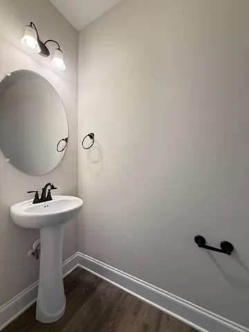 This clean and functional bathroom features a modern pedestal sink.