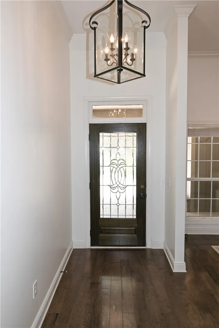 Inviting entryway with hardwoods and soaring ceilings, both of which continue into the formal dining room (far right).