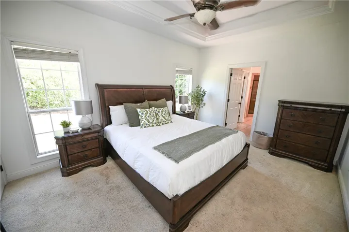 Spacious and serene primary bedroom with primary bath in background.