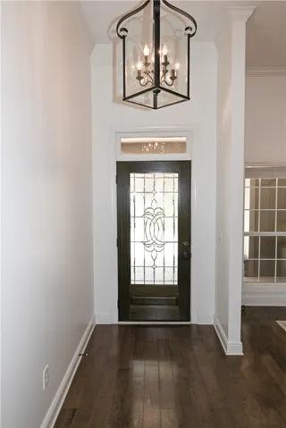 Inviting entryway with hardwoods and soaring ceilings, both of which continue into the formal dining room (far right).
