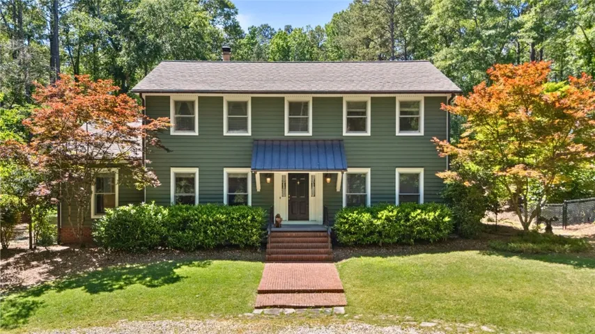 This charming home features a classic facade and inviting brick pathway.