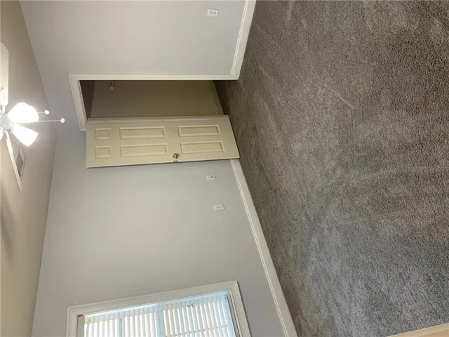 This cozy bedroom features plush carpeting and a convenient ceiling fan.