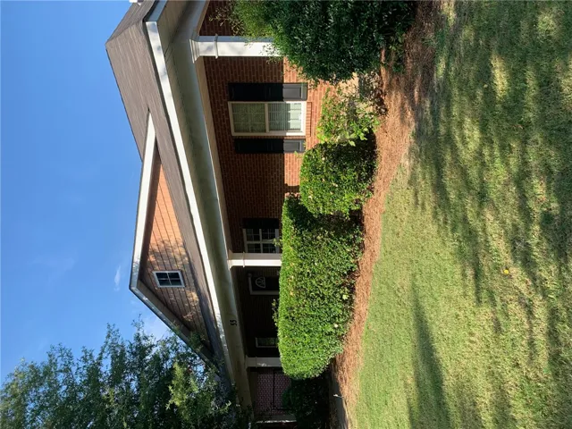 This classic brick residence features traditional shutters and lush, well-maintained landscaping.