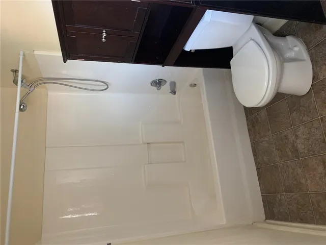 This clean and functional bathroom features a shower and toilet, offering convenience and practical design.
