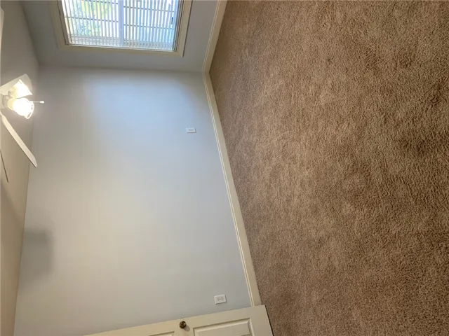 This cozy bedroom features plush carpeting and abundant natural light.