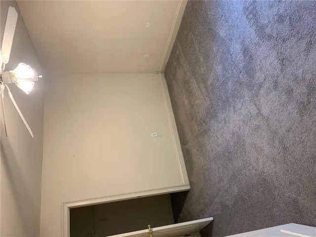 This interior space features plush carpet flooring and a ceiling fan for optimal comfort.