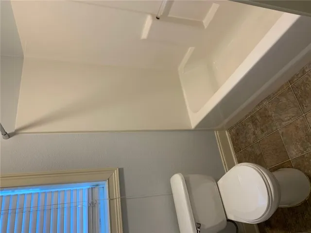This bathroom features a shower-tub combination and classic tile flooring.