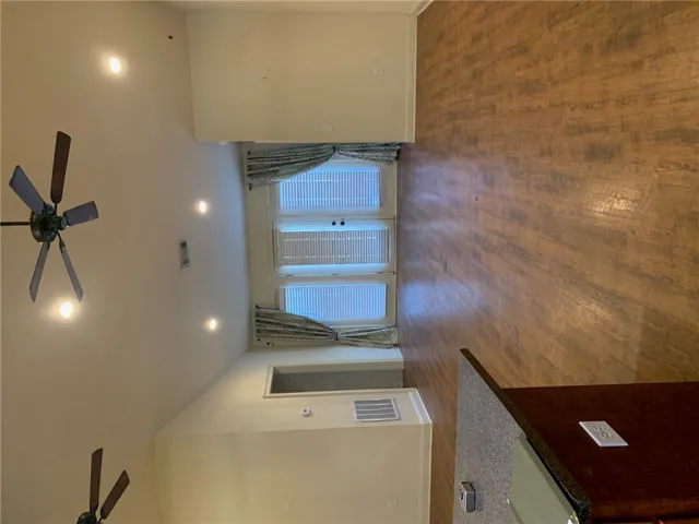 This expansive great room features lofty ceilings and durable hardwood flooring.