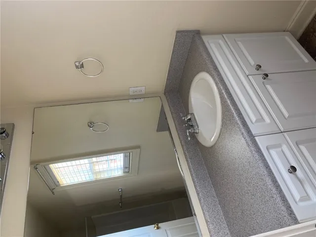 This bright bathroom features a spacious vanity with integrated sink and ample storage.