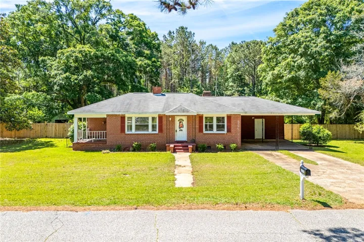 This charming residence features a classic brick exterior and a lush green lawn. 3 bedrooms/ 2 bath on over half an acre!