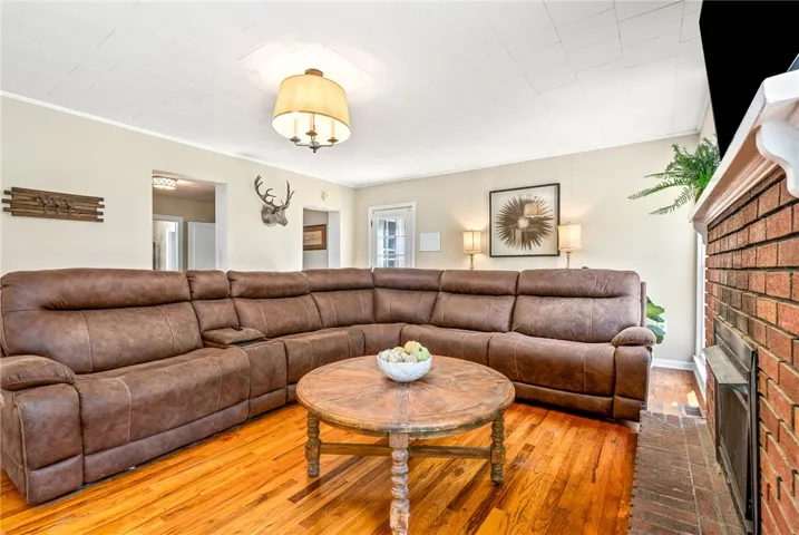 This inviting living area boasts rich hardwood floors and a classic brick fireplace.