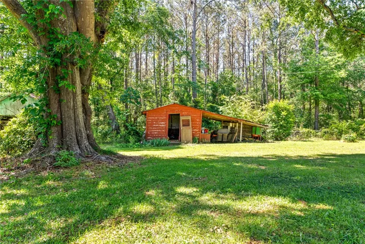 This expansive lot features mature trees and a versatile outbuildings.